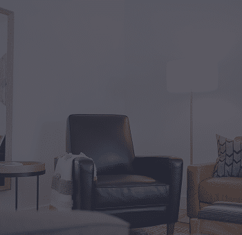 Black leather armchair in a dark living room.