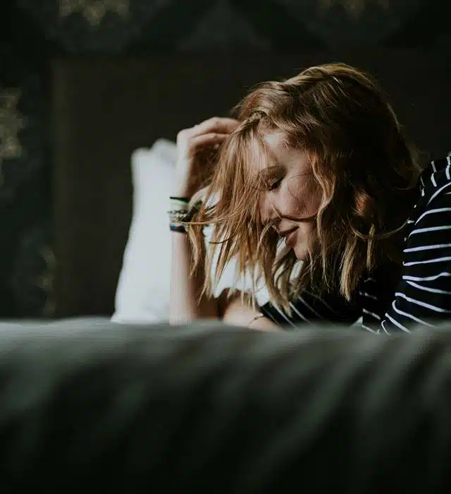 Woman lying down, touching hair.