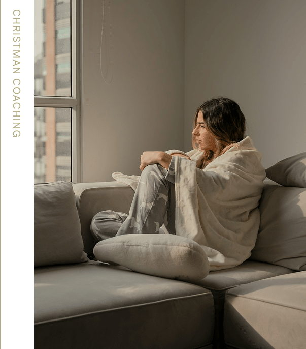 Woman on couch looking out window.