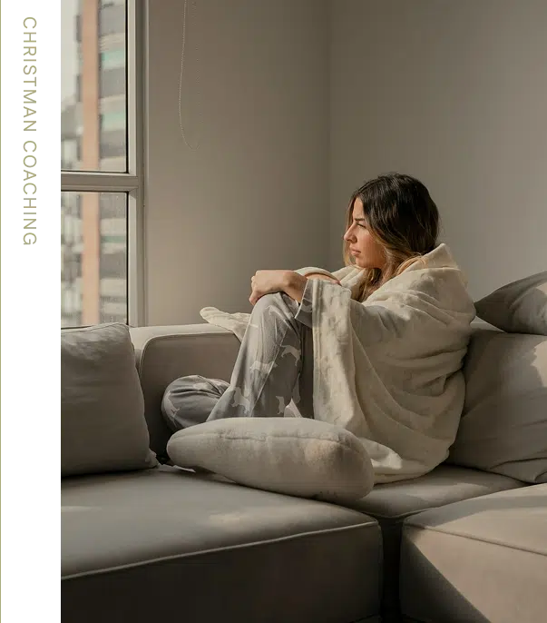 Woman on couch looking out window.