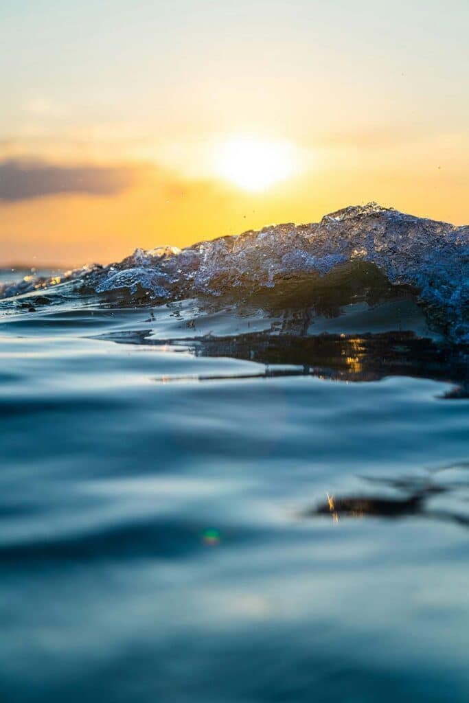Golden-sun-sets-behind-a-cresting-ocean-wave