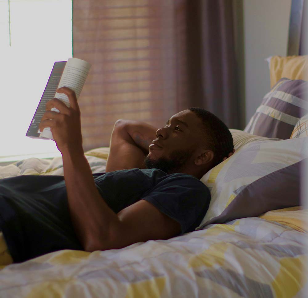 Man reading a book in bed.