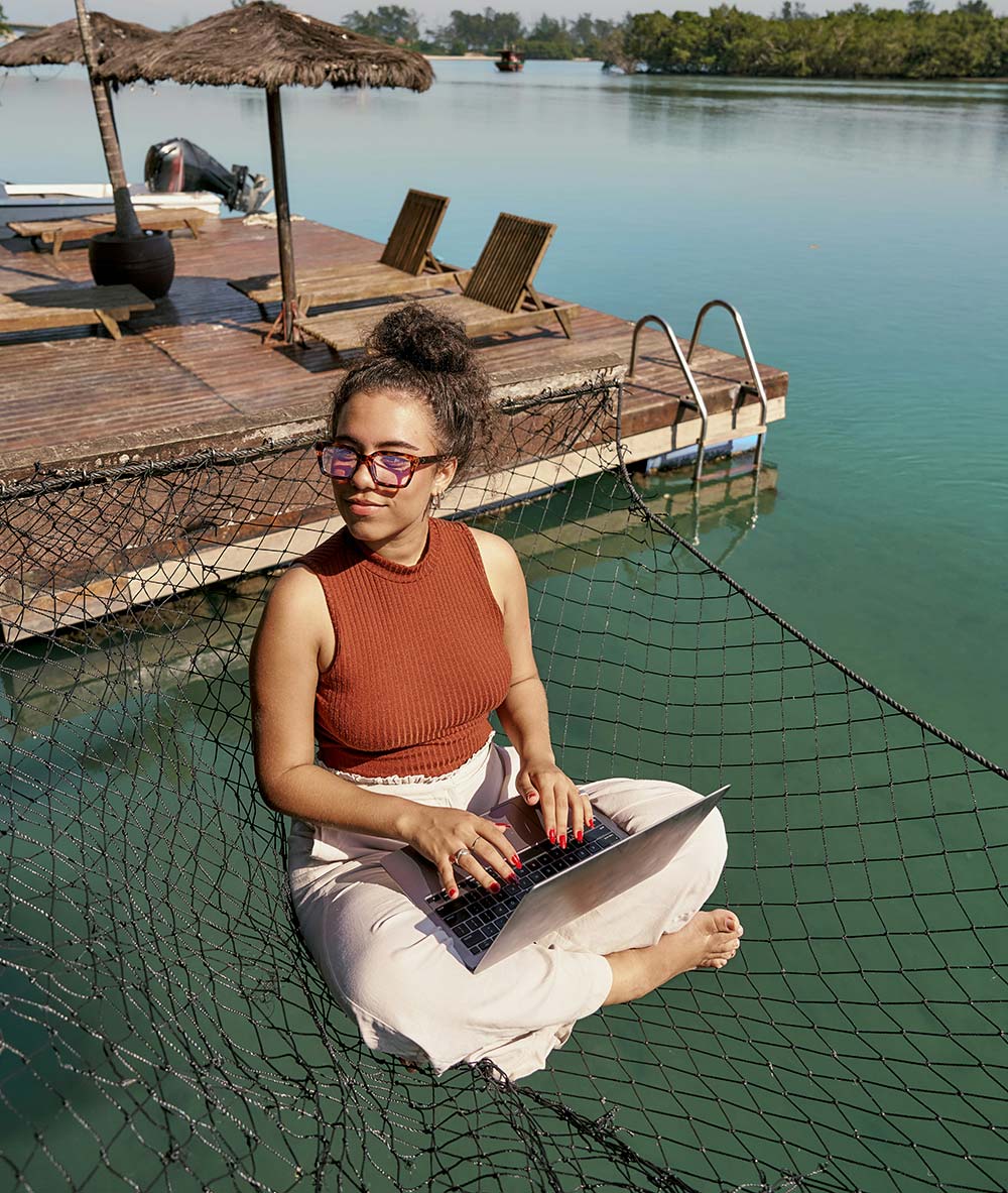 Woman in hammock using laptop.
