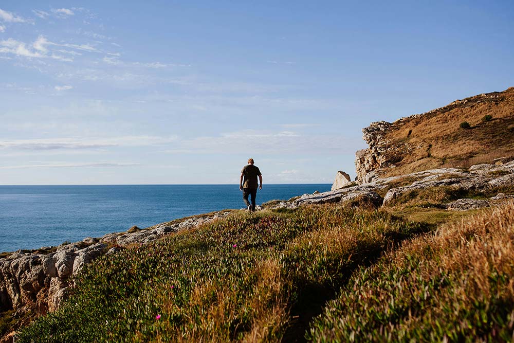 a man standing on a cliff overlooking the ocean