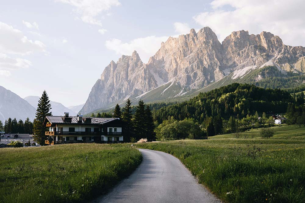 majestic-mountains-tower-over-a-building-and-green-fields